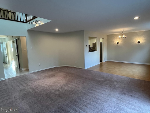 carpeted spare room with an inviting chandelier