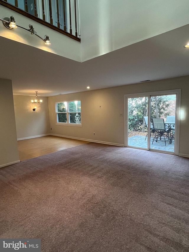 unfurnished living room with carpet and a high ceiling