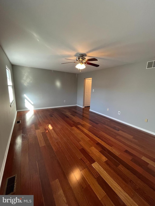 unfurnished room with dark hardwood / wood-style flooring and ceiling fan