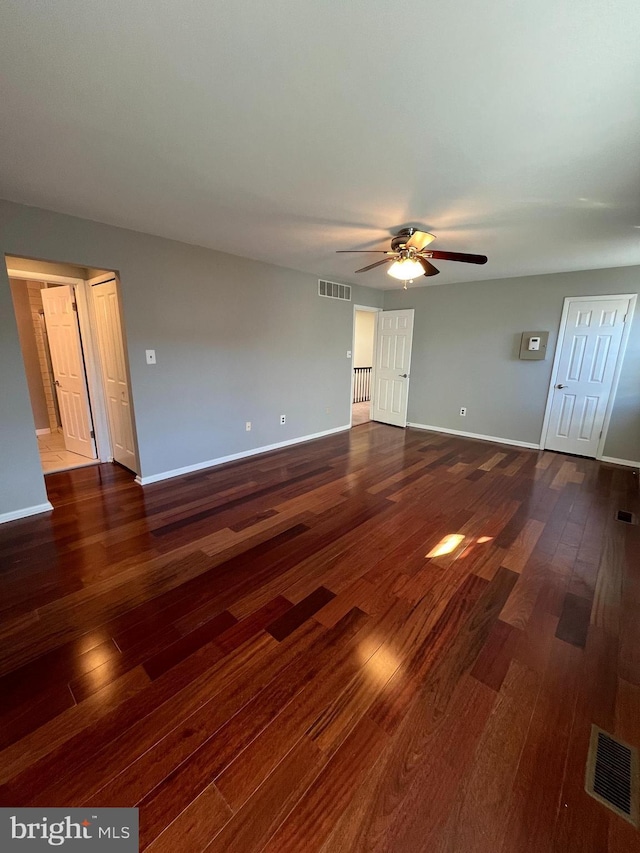 unfurnished living room featuring ceiling fan and dark hardwood / wood-style floors