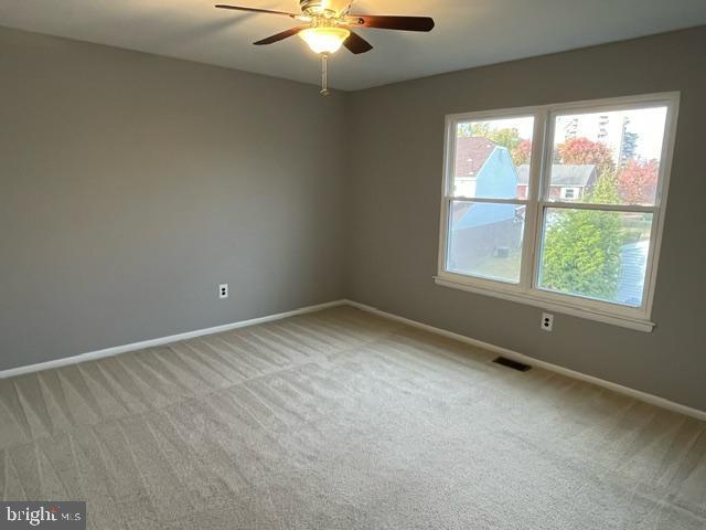 empty room with light carpet and ceiling fan