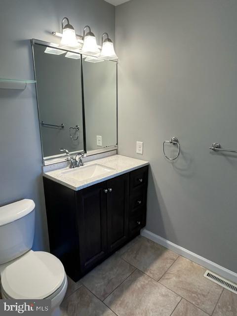 bathroom featuring vanity, tile patterned floors, and toilet