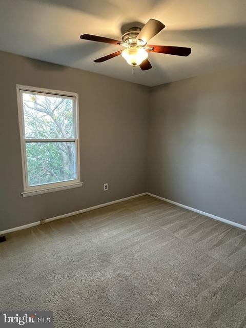 carpeted empty room featuring ceiling fan