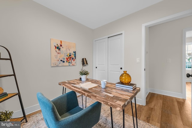 home office with light hardwood / wood-style flooring