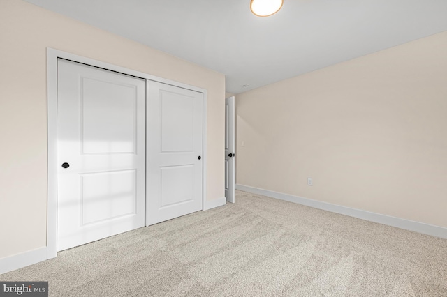 unfurnished bedroom with a closet and light carpet