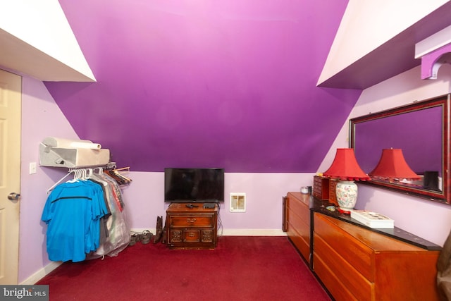 bonus room with dark colored carpet and lofted ceiling