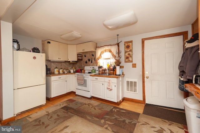 kitchen with white cabinetry, white appliances, decorative backsplash, and light wood-type flooring