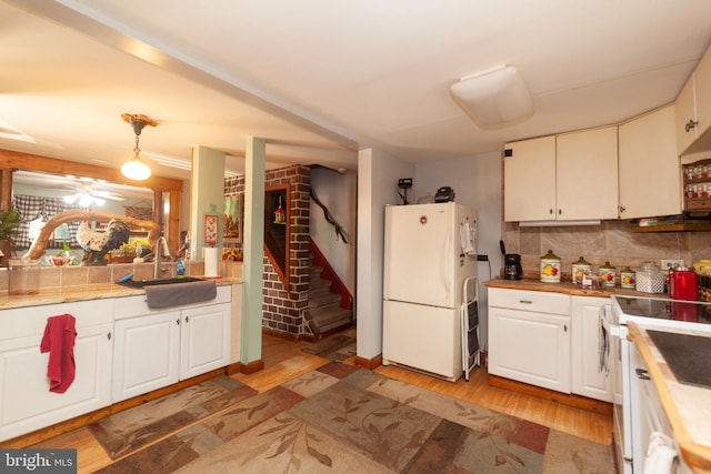 kitchen with white cabinetry, wood-type flooring, sink, and white appliances