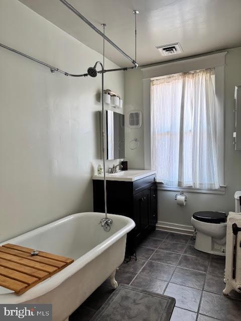 bathroom featuring vanity, a bathtub, and toilet