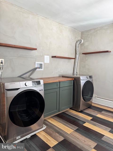 washroom featuring cabinets, dark wood-type flooring, and independent washer and dryer