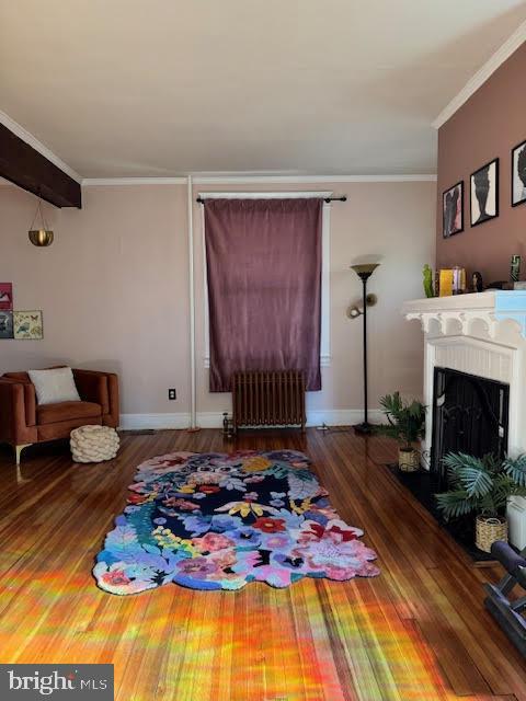 living room featuring ornamental molding, radiator, and dark hardwood / wood-style flooring