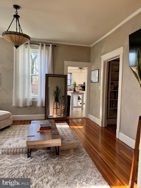 sitting room with hardwood / wood-style floors and ornamental molding