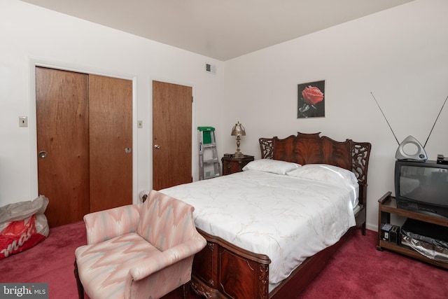 bedroom featuring two closets and dark carpet