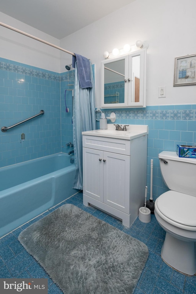 full bathroom featuring shower / tub combo with curtain, toilet, tile walls, vanity, and tile patterned flooring