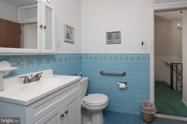 bathroom with vanity, tile walls, and toilet