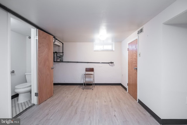 bathroom with hardwood / wood-style flooring and toilet