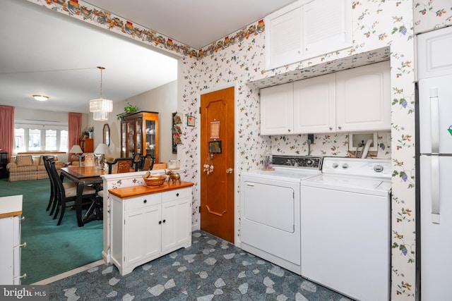 laundry area featuring a chandelier and washer and clothes dryer