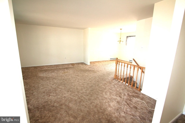 carpeted empty room with baseboard heating and a notable chandelier