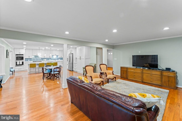 living room with ornamental molding and light wood-type flooring