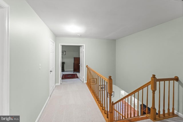 hallway featuring light colored carpet