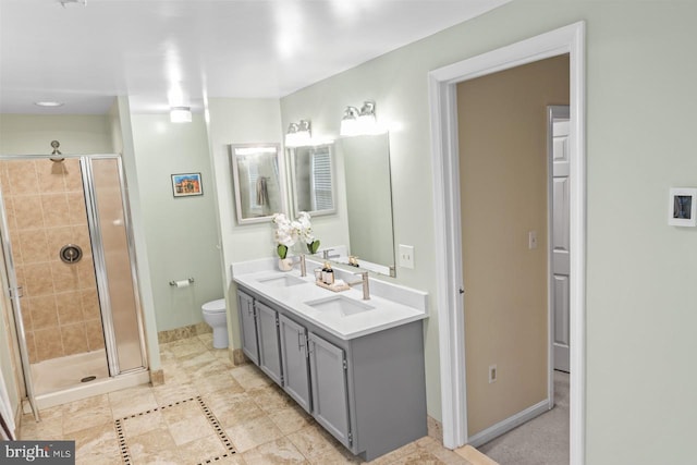 bathroom featuring an enclosed shower, vanity, and toilet