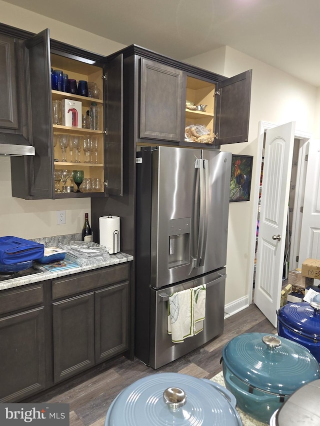 kitchen with dark hardwood / wood-style floors, dark brown cabinetry, light stone countertops, black electric cooktop, and stainless steel fridge with ice dispenser