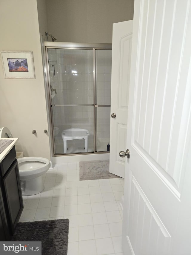 bathroom with tile patterned floors, vanity, toilet, and an enclosed shower