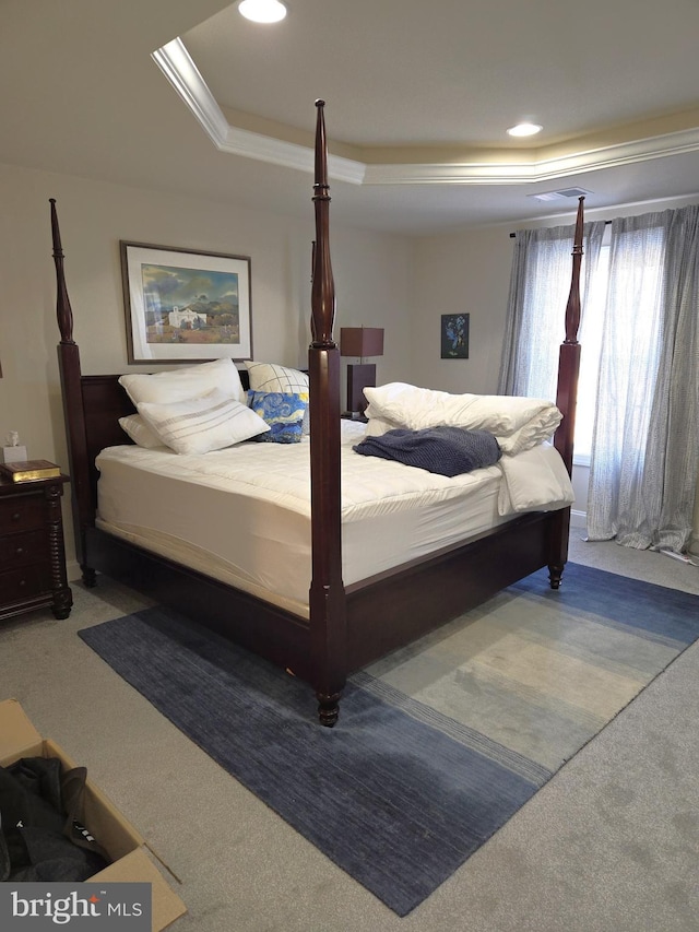 bedroom featuring ornamental molding, carpet flooring, and a raised ceiling