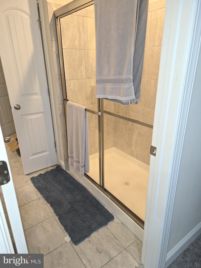 bathroom with walk in shower and tile patterned flooring