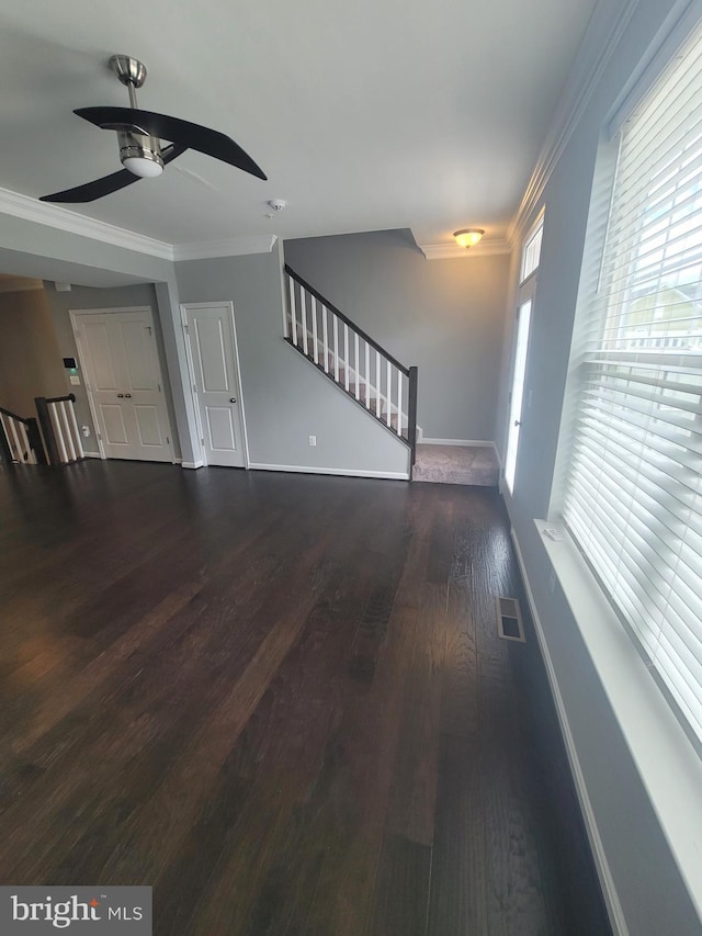 unfurnished living room featuring crown molding, ceiling fan, and dark hardwood / wood-style flooring