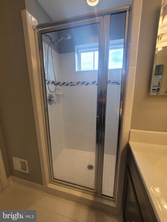 bathroom with vanity, tile patterned flooring, and a shower with door