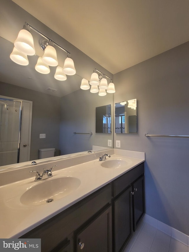 bathroom with tile patterned flooring, vanity, an enclosed shower, and toilet