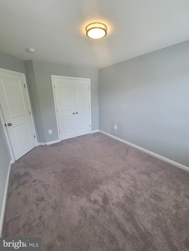 unfurnished bedroom featuring carpet floors and a closet