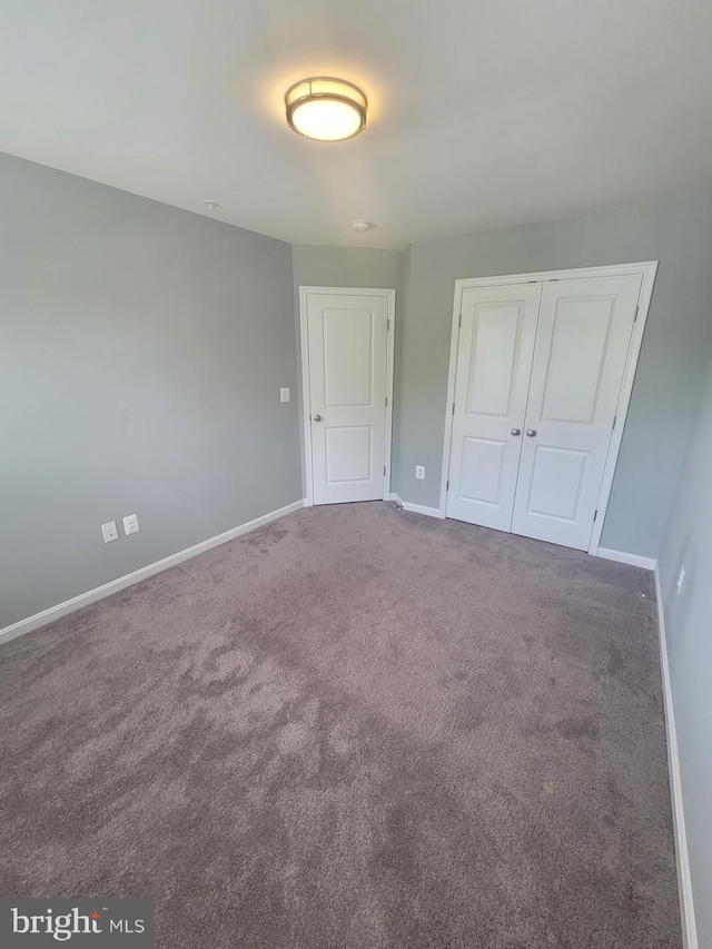 unfurnished bedroom featuring carpet and a closet