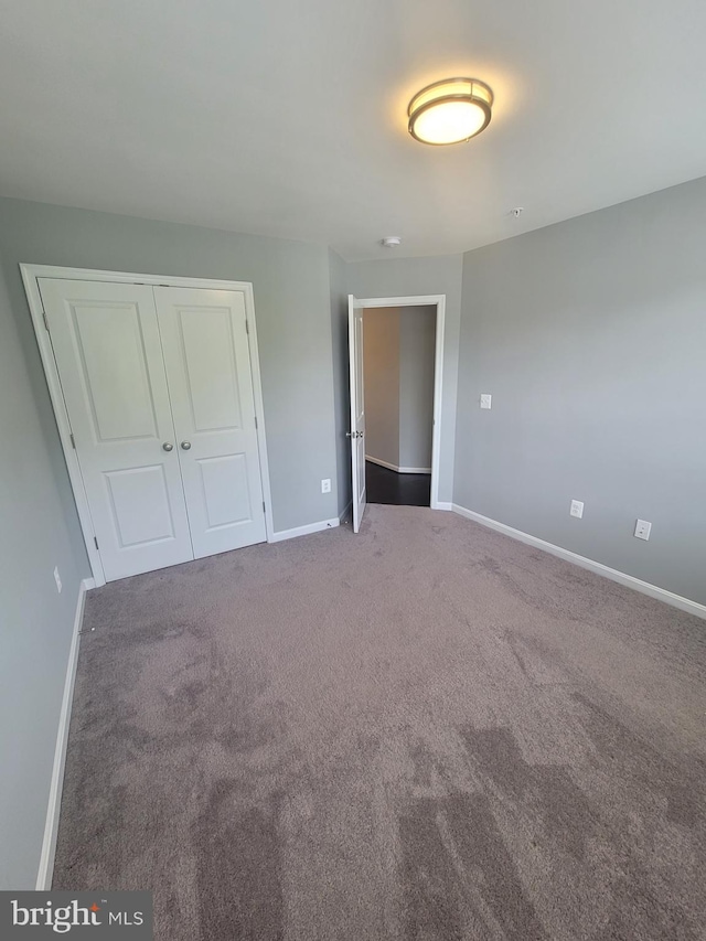 unfurnished bedroom with carpet floors and a closet