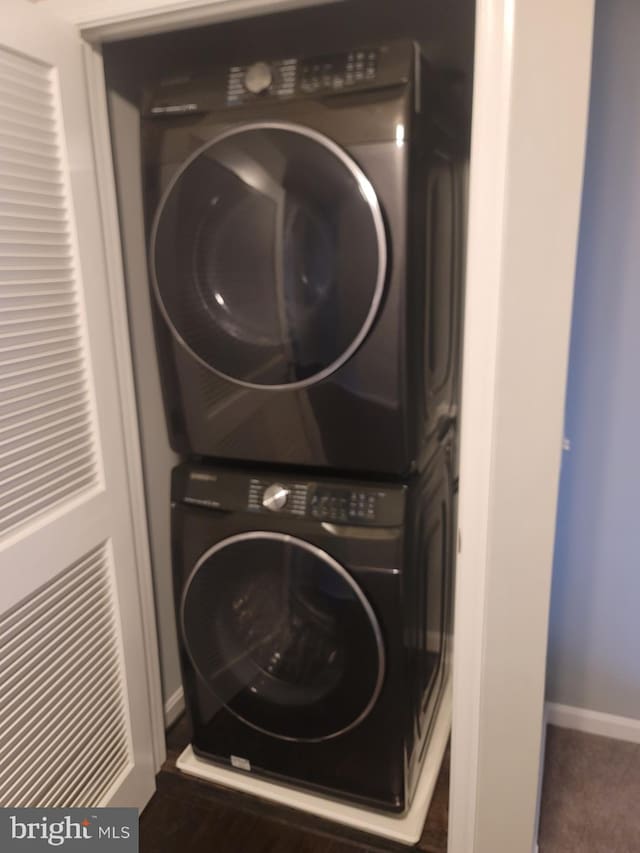 clothes washing area featuring stacked washer / dryer