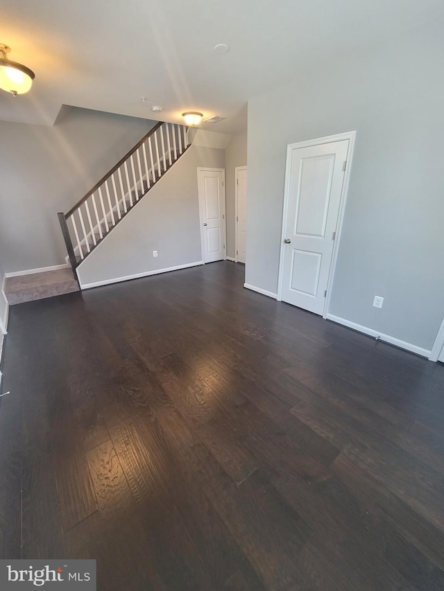 unfurnished living room with dark wood-type flooring