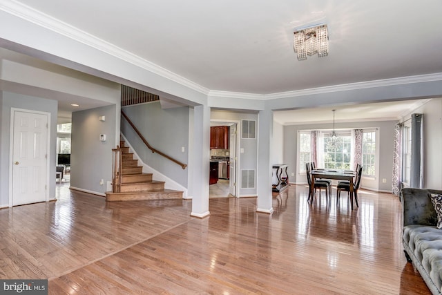 interior space featuring crown molding, hardwood / wood-style floors, and a notable chandelier