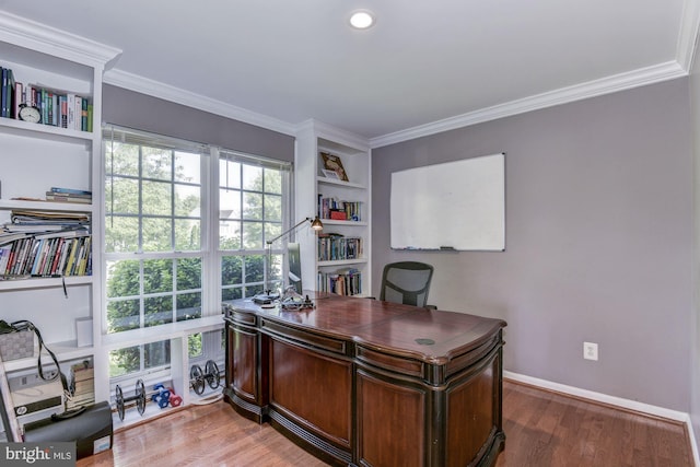 office space with built in shelves, ornamental molding, and hardwood / wood-style floors