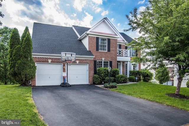 view of front of home featuring a garage, a balcony, and a front lawn