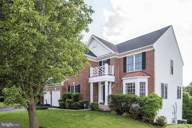 view of front of property featuring a balcony, a garage, and a front yard