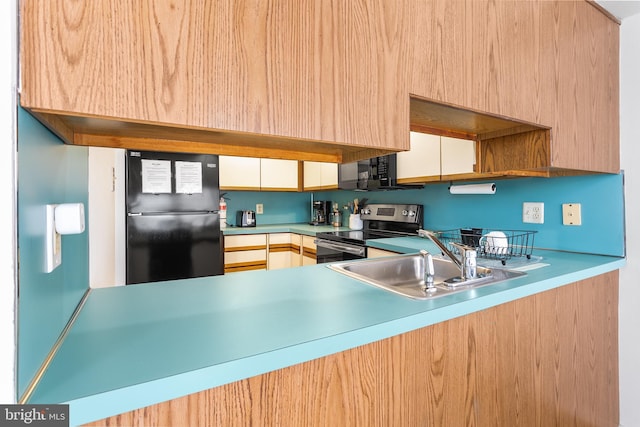 kitchen featuring sink, light brown cabinets, and black appliances