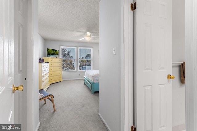 bedroom featuring light carpet and a textured ceiling