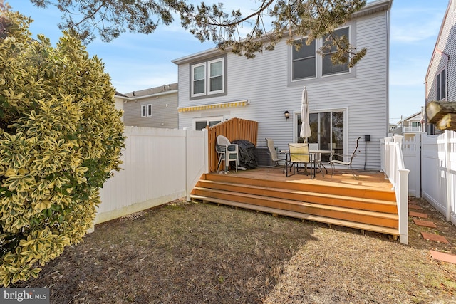 rear view of property featuring a wooden deck