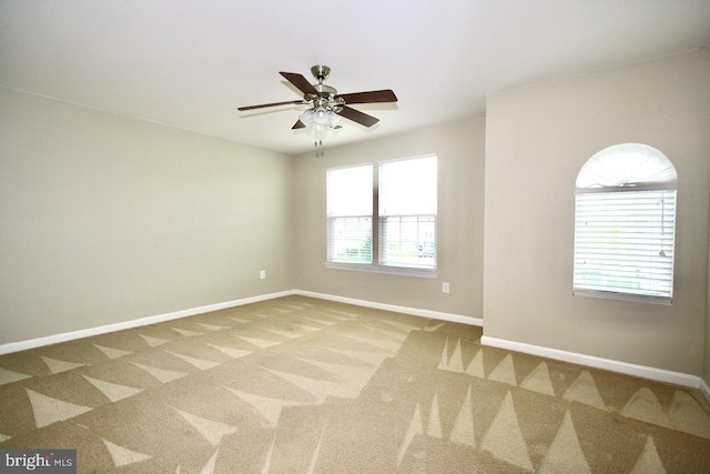 carpeted spare room with ceiling fan