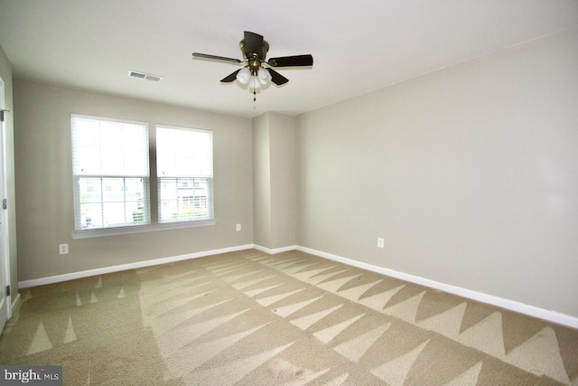 carpeted spare room featuring ceiling fan