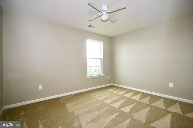 carpeted spare room with ceiling fan