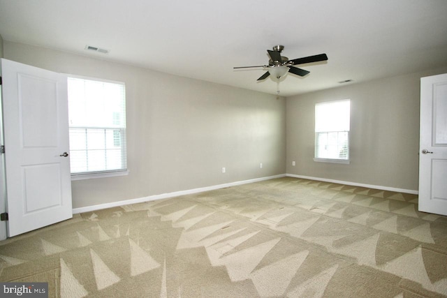 empty room featuring light colored carpet and ceiling fan