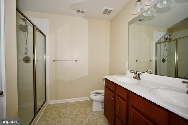 bathroom with vanity, toilet, and a shower with door