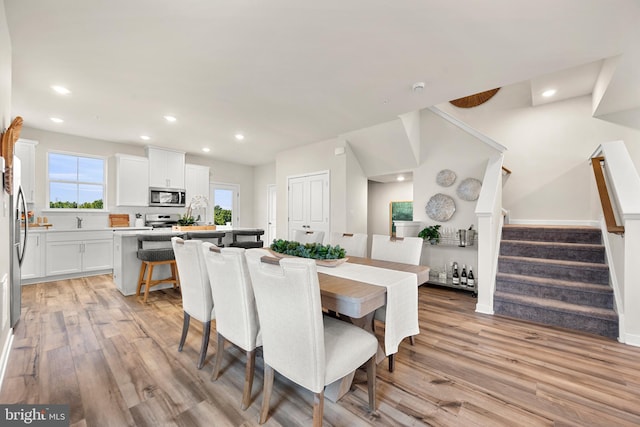 dining space with sink and light wood-type flooring